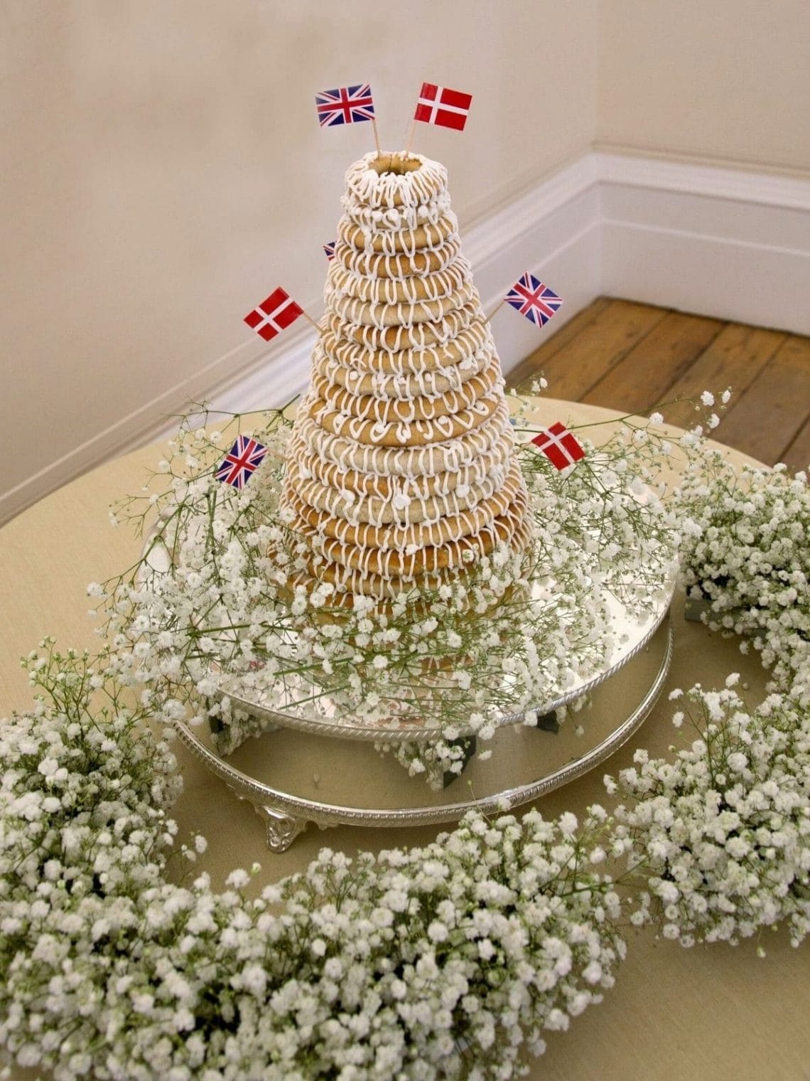 Danish Kransekage tower - marzipan wreath cake or ring cake - a recipe for a classic Danish cake. Use it for weddings, Christmas, New Year, or any party that needs a fancy cake. Find recipes and inspiration @ danishthings.com Photo © Christina F. I. #DanishThings #kransekage # marzipanwreathcake #ringcake #Danish #tradition #weddingcake #NewYear #christmas #cake #party #classic #festive #tower