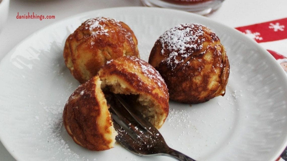 Aebleskiver - Puff dumplings - Apple dumplings - Filled pancakes - Pancake balls – in Danish æbleskiver. The most delicious filled aebleskiver. Danes eat them at Christmastime – you can eat them whenever you like. Fill your aebleskiver with apple compote, jam, marmalade or with extra batter and have nice round aebleskiver. Eat them as they are or serve them with sugar and marmalade. Find the recipe and inspiration for your Danish inspired Christmas @ danishthings.com #DanishThings # Aebleskiver #Puff-dumplings #Apple-dumplings #Filled-pancakes #Pancake-balls #round #pancakes #sweet #dumpling #Danish #æbleskiver #Christmas