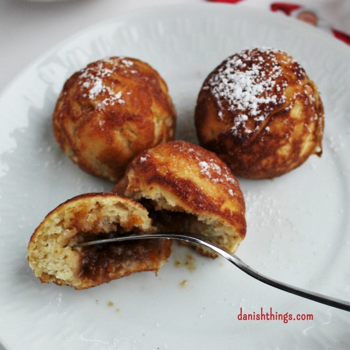 Aebleskiver - Puff dumplings - Apple dumplings - Filled pancakes - Pancake balls – in Danish æbleskiver. The most delicious filled aebleskiver. Danes eat them at Christmastime – you can eat them whenever you like. Fill your aebleskiver with apple compote, jam, marmalade or with extra batter and have nice round aebleskiver. Eat them as they are or serve them with sugar and marmalade. Find the recipe and inspiration for your Danish inspired Christmas @ danishthings.com #DanishThings # Aebleskiver #Puff-dumplings #Apple-dumplings #Filled-pancakes #Pancake-balls #round #pancakes #sweet #dumpling #Danish #æbleskiver #Christmas
